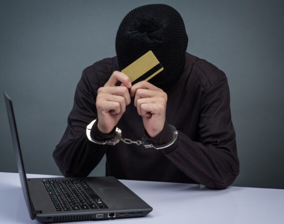a_scammer_holds_a_stolen_credit_card_after_getting_busted