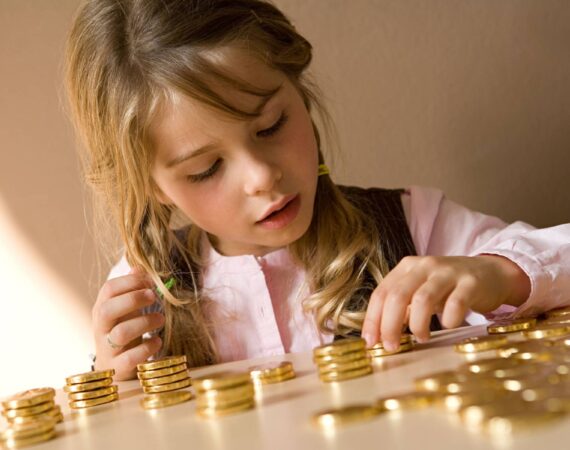 young girl counting her money on table